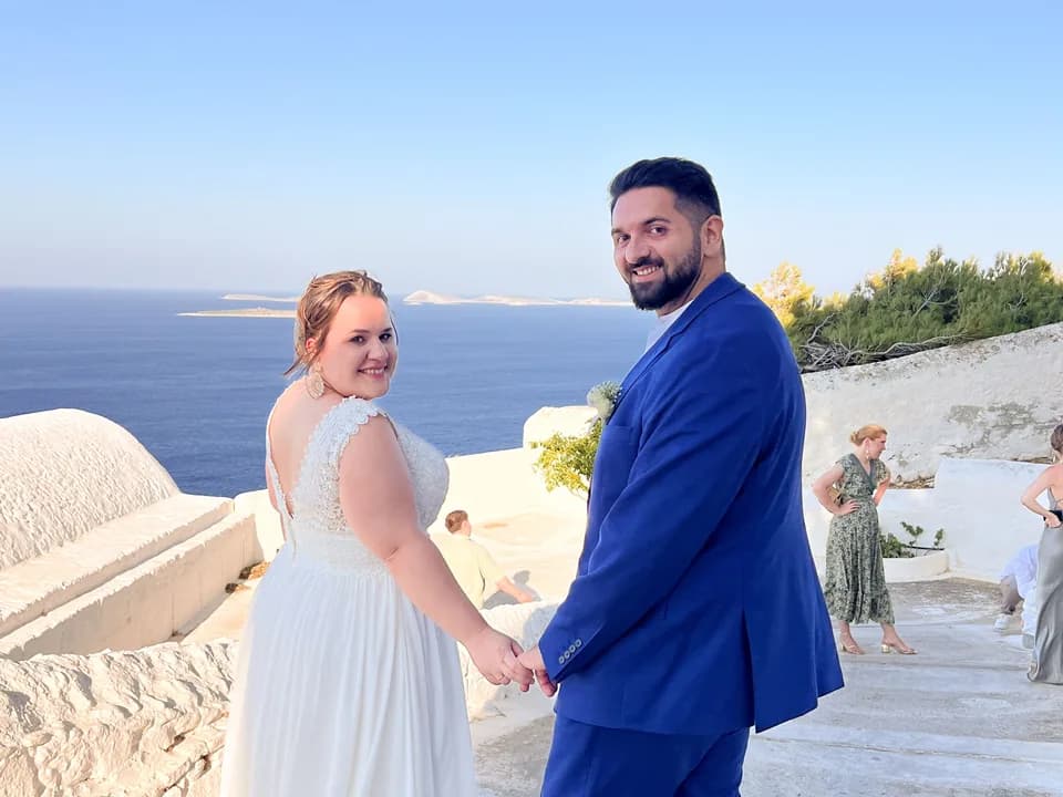 Bernhard and Lisa turning around hand in hand on a terrace above the sea.