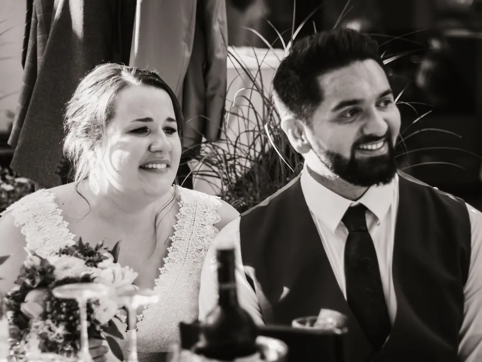 Bernhard and Lisa smiling at the wedding table, black-and-white photo.